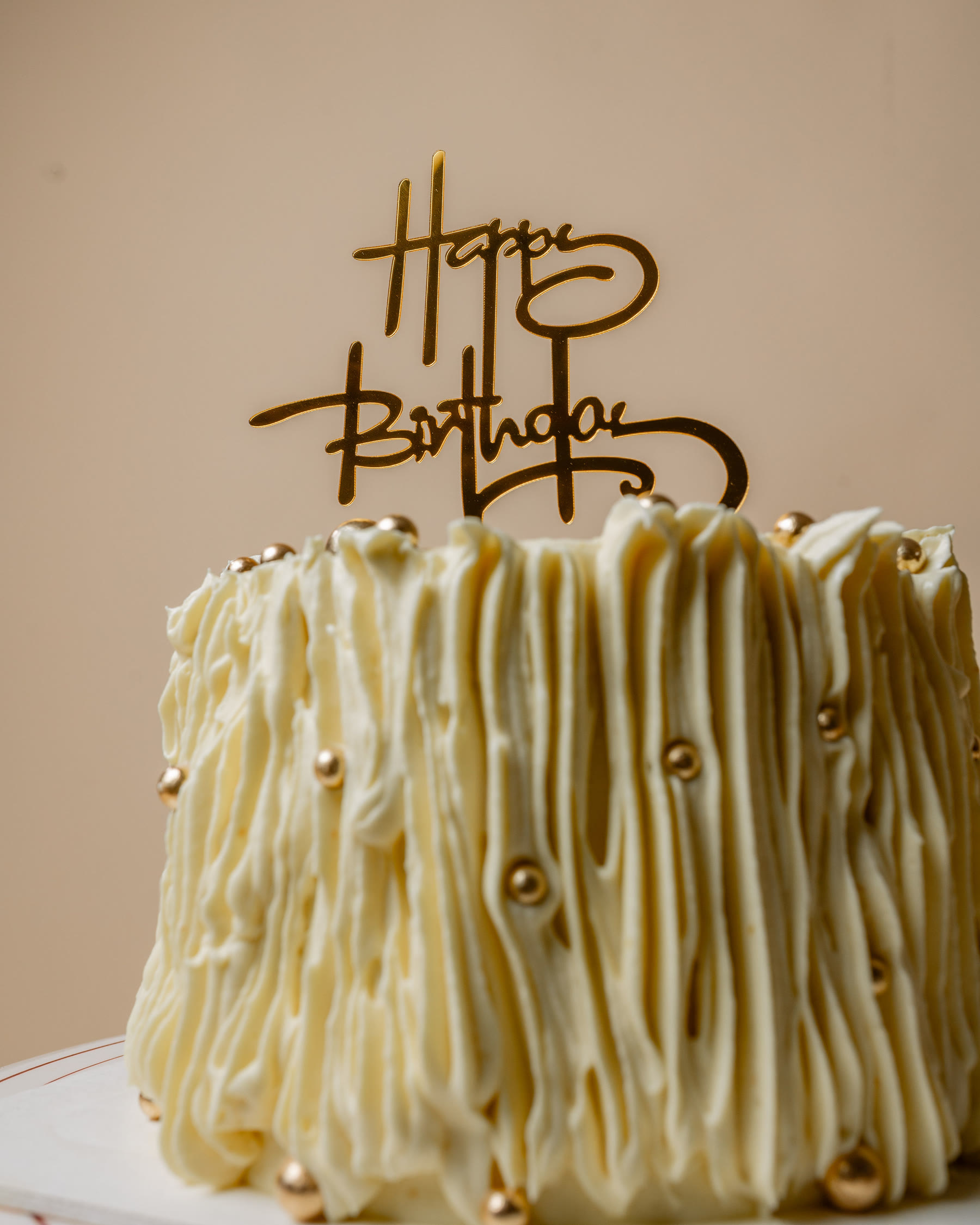White celebration cake with gold pearls