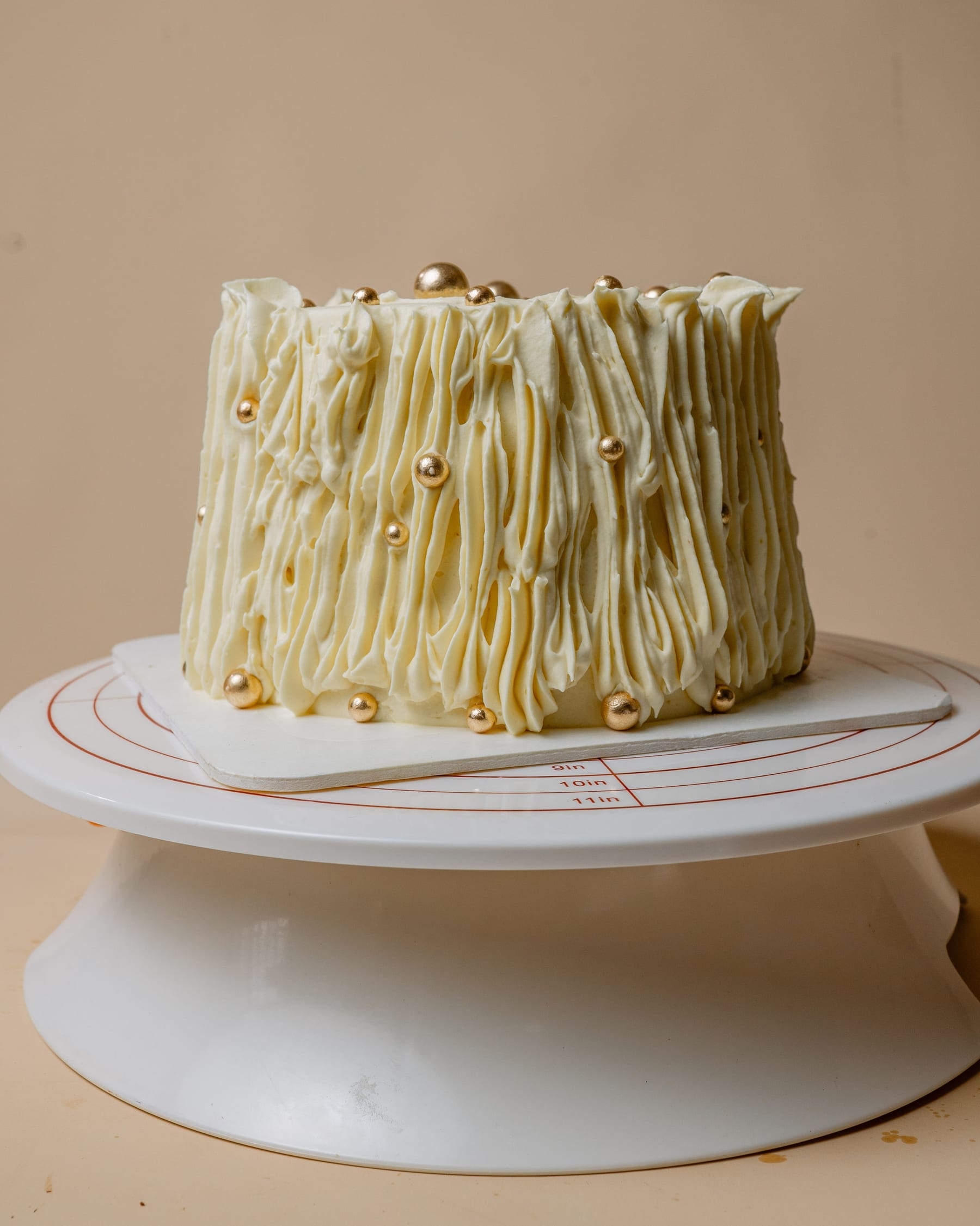 Handcrafted celebration cake with gold pearls, finished by Chef Safoa